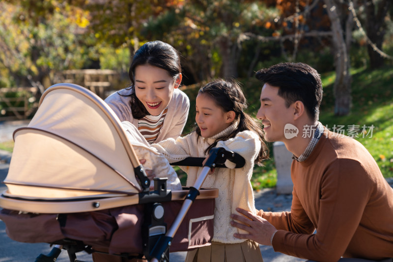 年轻夫妻推着婴儿车散步