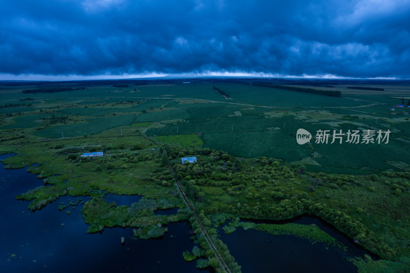 航拍乌云下的湿地田野景观