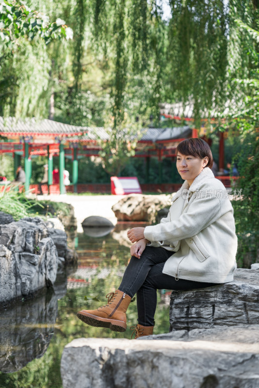 坐在公园湖边欣赏风景的中国女性