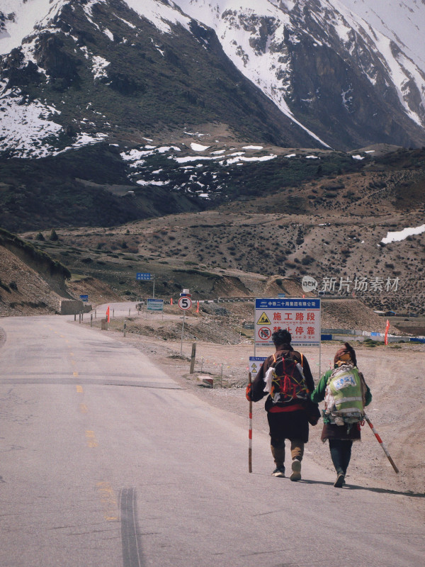 两人在雪山公路徒步