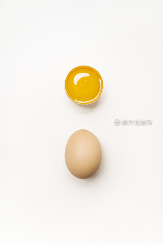 一枚完整的鸡蛋和一枚被打开的鸡蛋黄
