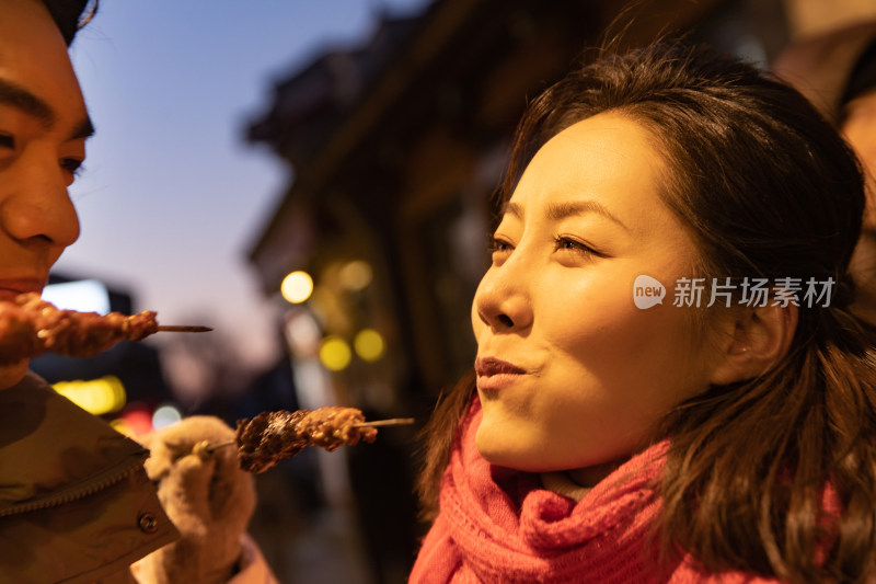 青年夫妇逛街吃羊肉串