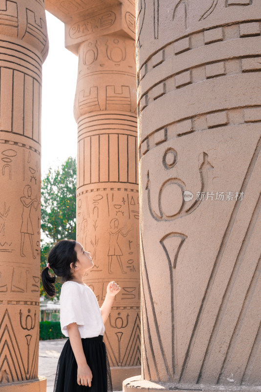 正在观察公园石柱上雕刻的中国女孩