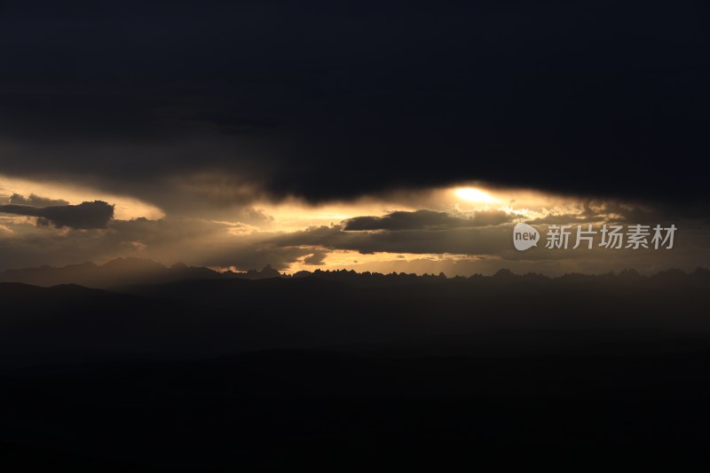 山峰日落时天空映衬的剪影景观