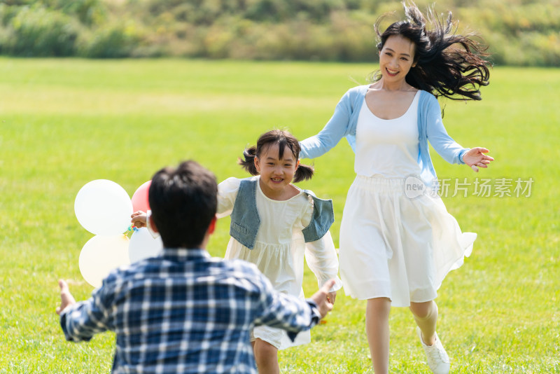 妈妈和女儿开心地跑向爸爸的怀抱