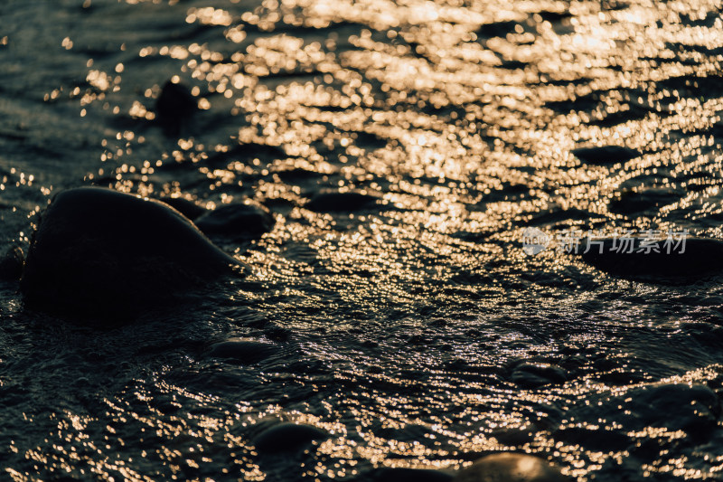 日落时阳光洒在波光粼粼的水面上