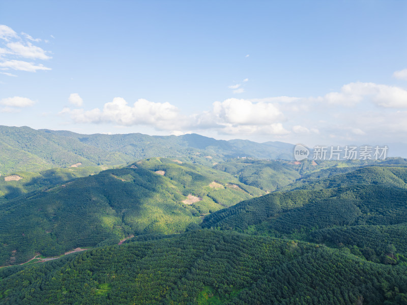 航拍蓝天白云下广阔无垠绿意盎然的山地景观