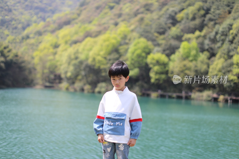 站立在湖边的中国小男孩