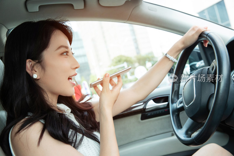 青年女人边开车边语音聊天