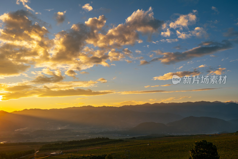 黄昏时分阳光穿透云层的山间风光