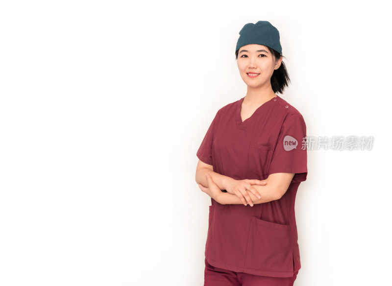 白色背景前穿着手术服的中国年轻女性医生
