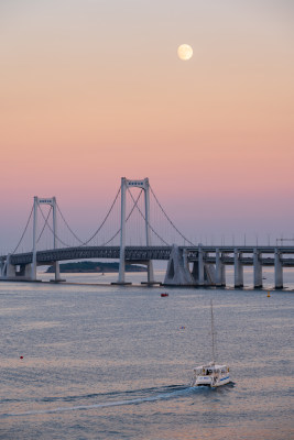 夕阳下大连星海湾大桥上空升起的月亮