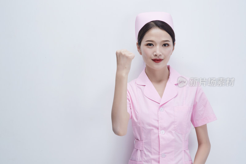 身穿粉色护士服佩戴听诊器的女性医护人员