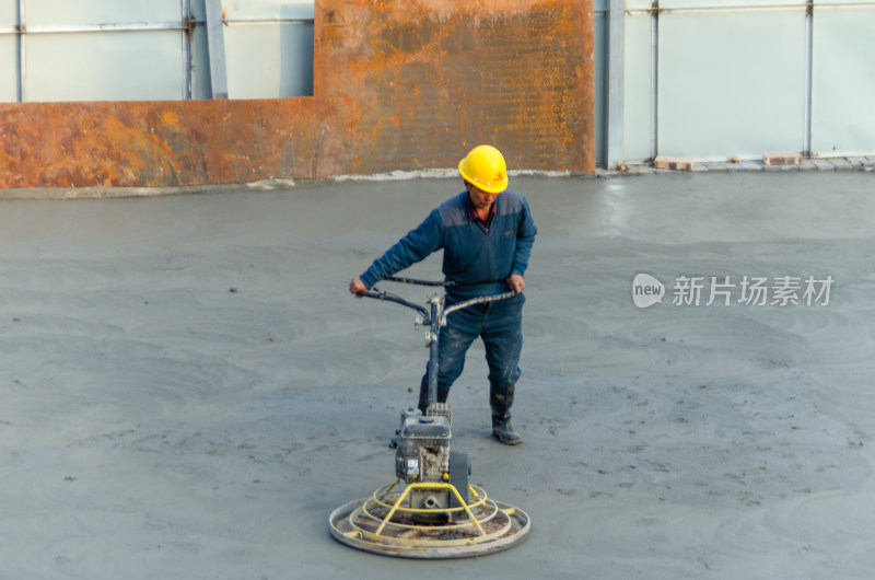 建筑工地上，工人使用路面抹平机平整路面