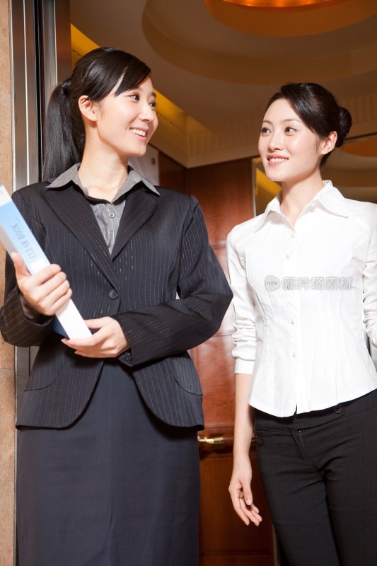 两个年轻商务女士走出电梯