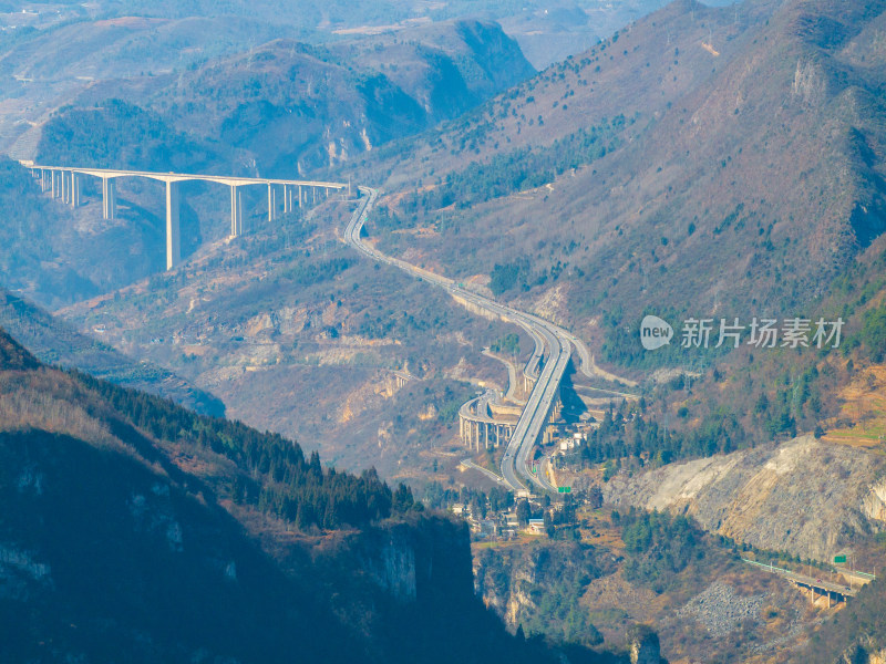 山间城镇全景，高架公路贯穿其中