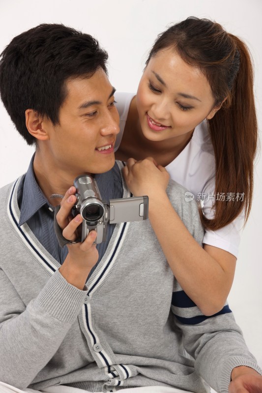 情侣拿着数码录像摄像机