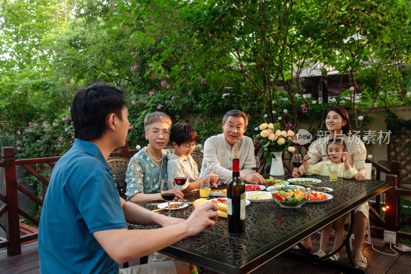 快乐大家庭在庭院里用餐