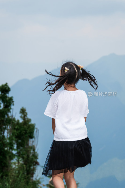 晴朗的夏天午后走在盘山公路上的东方女孩