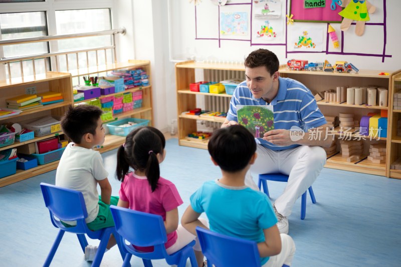 幼儿园外教男老师和小朋友们一起看画册