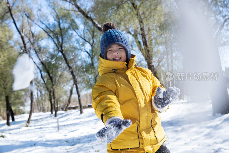 快乐的小男孩在雪地里玩耍