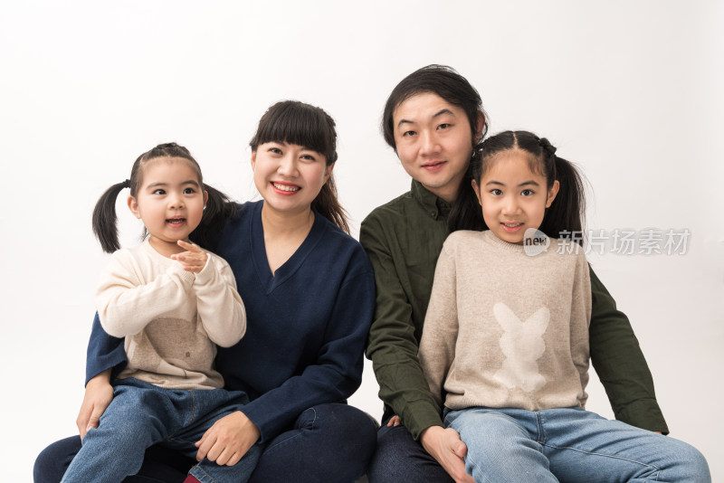 坐在白色背景前的中国父母和女儿