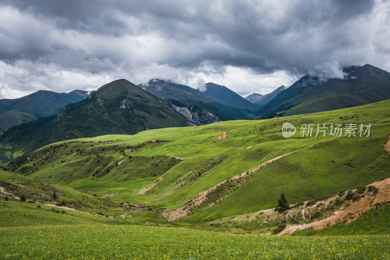 蓝天白云下广袤草原与连绵山峦自然风景