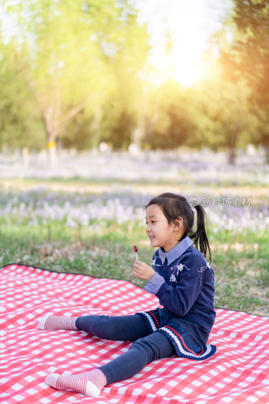 春天在公园草坪上野餐的中国女孩