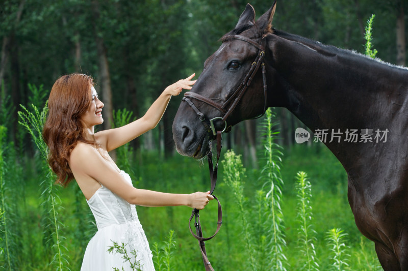 草地上快乐的年轻女人和马