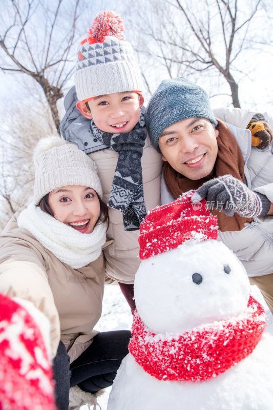 一家三口在雪地里堆雪人