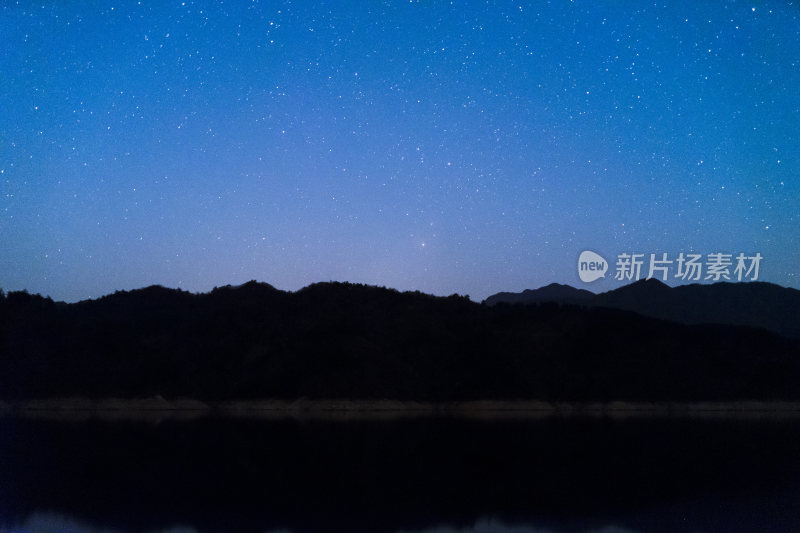 繁星密布的夜空下的山峦与湖水