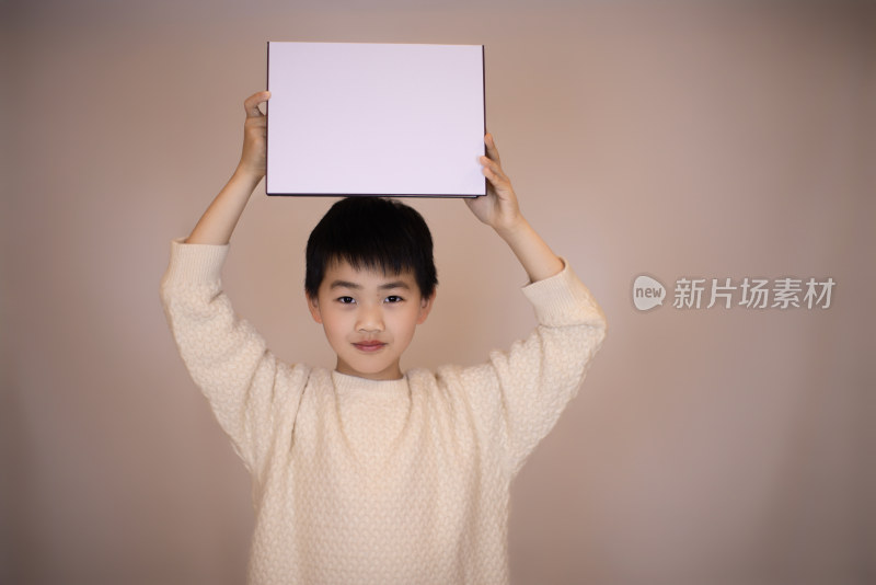 一个帅气的中国小男孩在展示白板