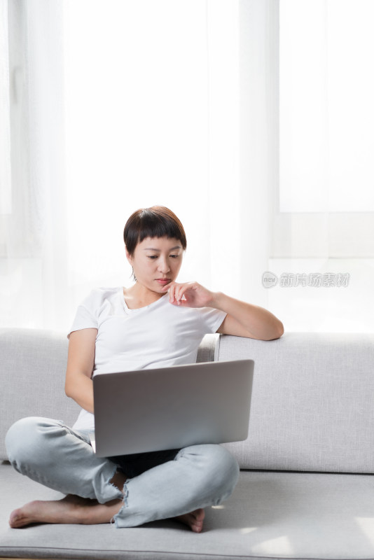 坐在沙发上使用笔记本电脑女性