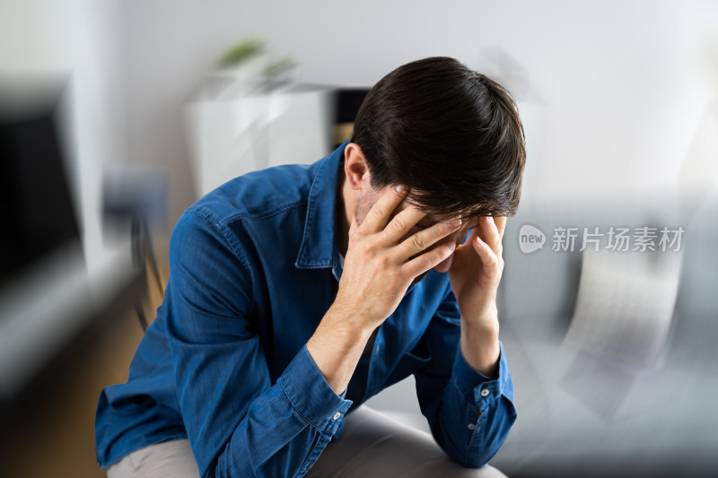 室内男子抱头显疲惫