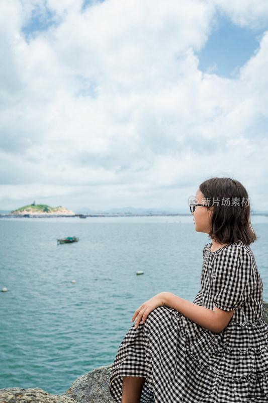 女孩海边石上静坐留影远眺大海