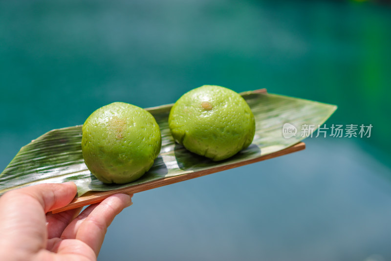 在湖边手拿青团的特写