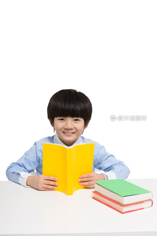 小男孩坐在书桌前看书