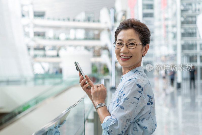 老年女人在机场使用手机