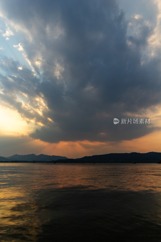 杭州西湖湖面夕阳下的山峦与云彩