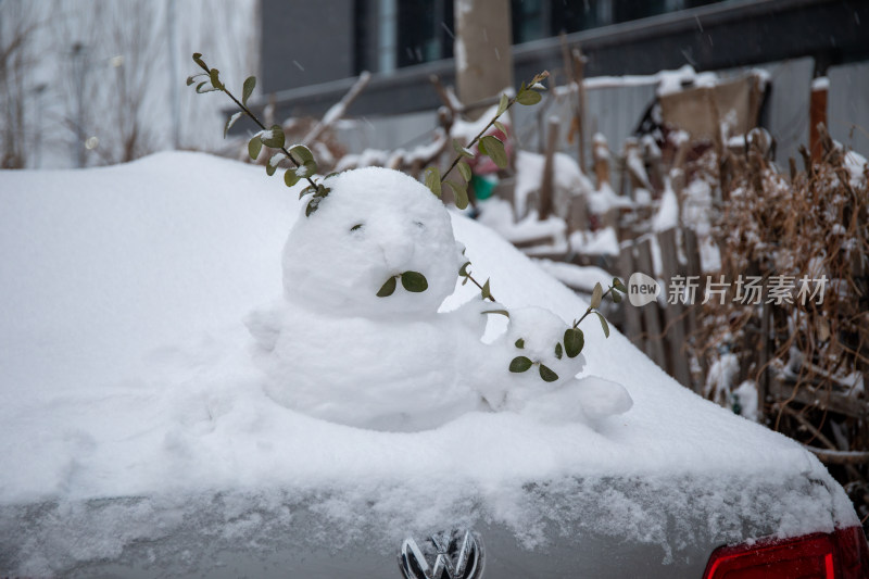 冬天汽车上堆雪人的照片