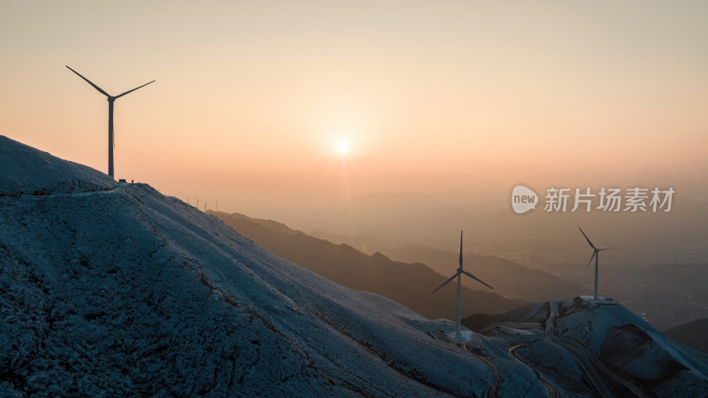 冬季日落时分桂林高山上的积雪和风力发电站