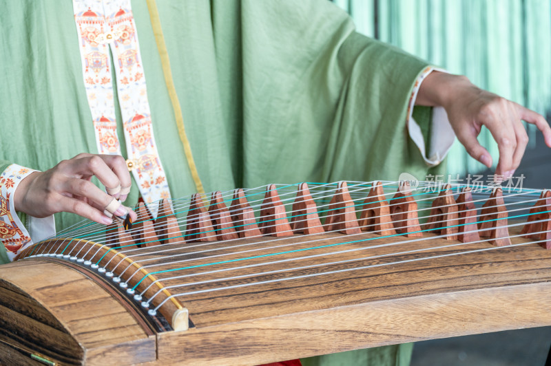 一位身穿中国传统汉服的女子弹奏古筝唯美
