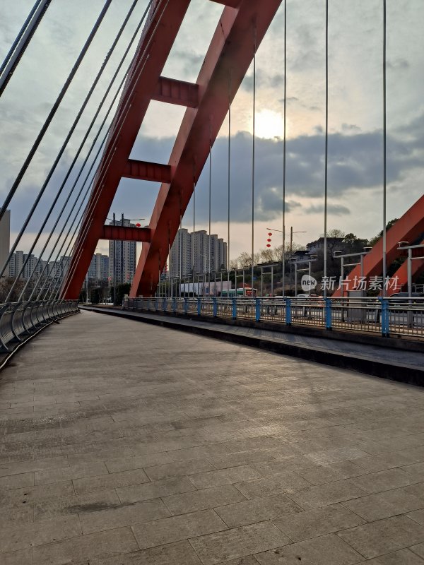 红色钢构桥梁及城市高楼远景