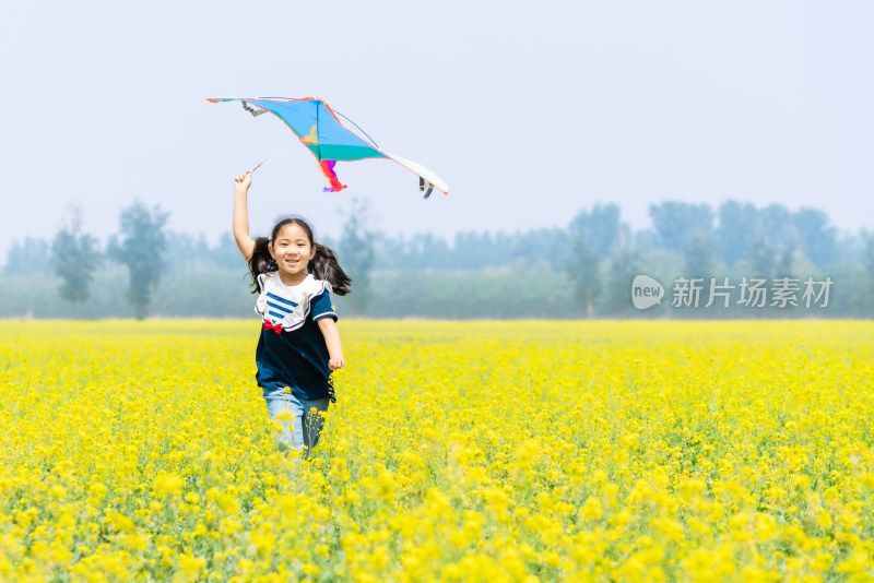 夏天拿着风车在油菜花田中奔跑的女孩