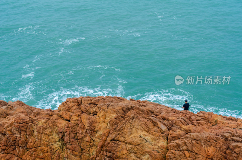 广阔的海岸边有一个垂钓者