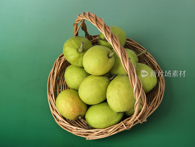 绿色背景上的一篮子新鲜水果香梨