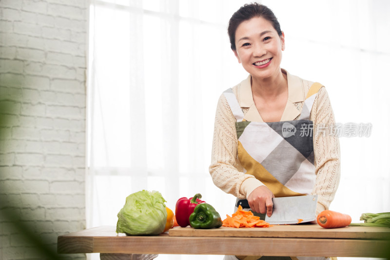 厨房内切菜的中年女性