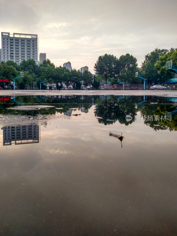 积水篮球场倒影天空绿树高楼景象