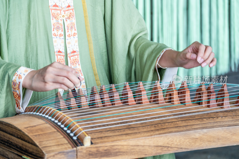 一位身穿中国传统汉服的女子弹奏古筝唯美