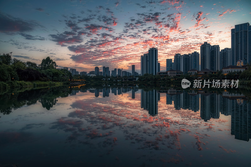 夏日黄昏晚霞红云城市建筑湖面倒影